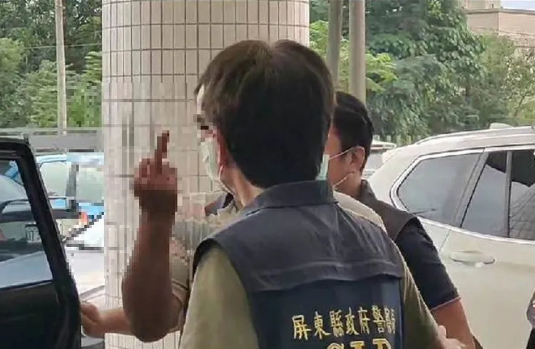 楊男被警移送時還比中指，氣焰囂張。讀者提供