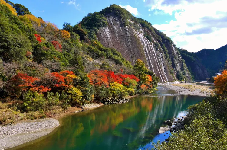 被指定為天然紀念物高100公尺、寬500公尺的「一枚岩」聳立在河川邊，穩如泰山的姿態與周邊大自然顏料彩繪上的黃紅色彩形成對比。古座川町觀光協會提供