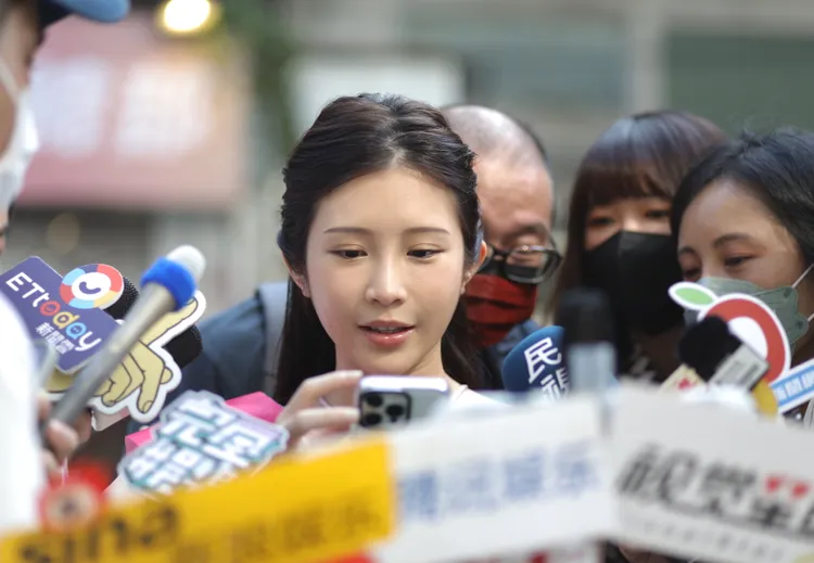 鄭家純（中）給媒體看老公照片。陳明中攝