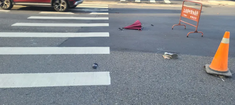 婦人球鞋與雨傘散落一旁。翻攝畫面