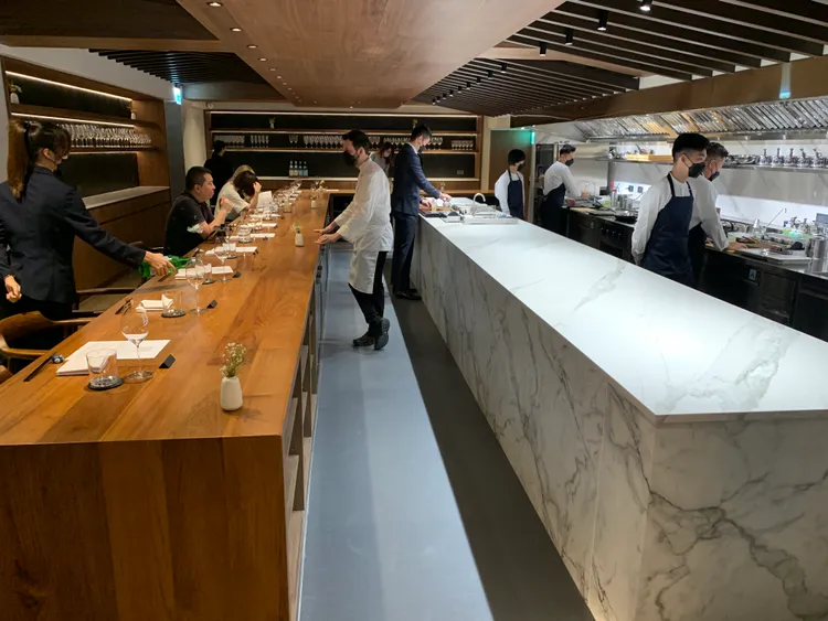 AD ASTRA店內以L型大長桌結合吧台、開放式廚房，可直接看到料理過程。劉欣欣攝