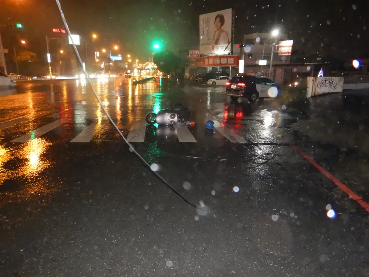 蔡姓女騎士機車倒地，肇事的黑色電線隨風擺盪。讀者提供