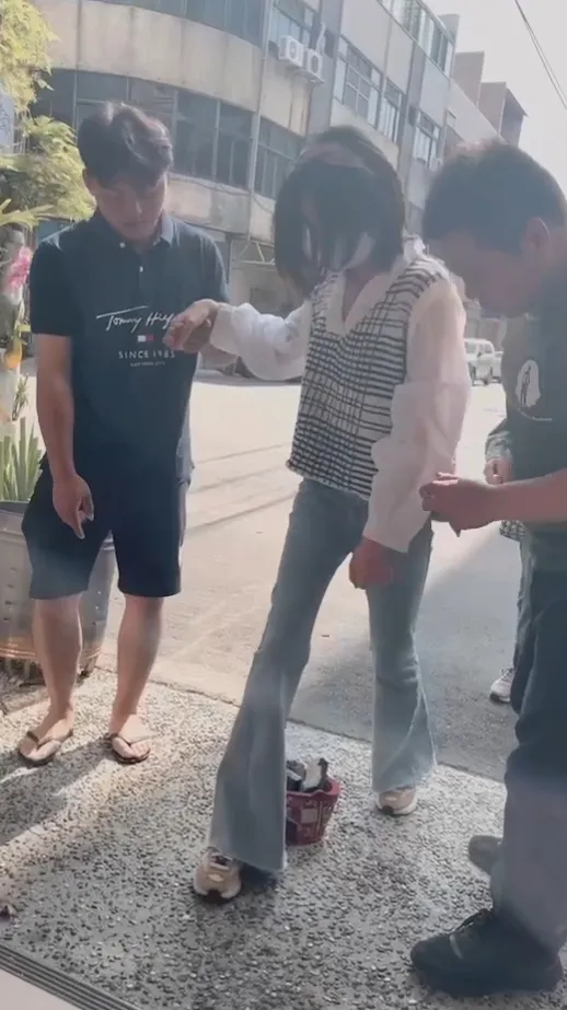 陳女由家人扶著「過火」後進入家門。陳父提供