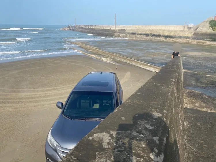 羅姓男子將車輛停放在沙灘上，未注意漲潮讓車輛陷入困境。讀者提供