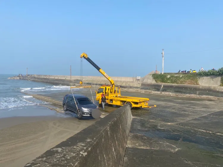 警方電召拖吊車利用吊掛方式，協助車輛脫困。讀者提供