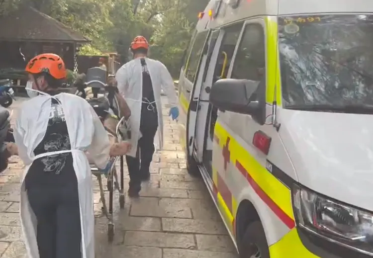 救護人員將溺水者抬上救護車送醫。讀者提供