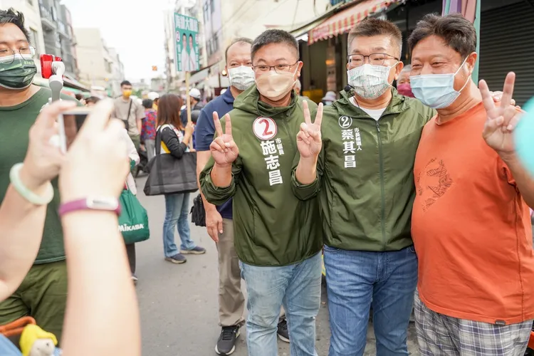 蔡其昌陪同施志昌拜票，與選民合影。蔡其昌總部提供