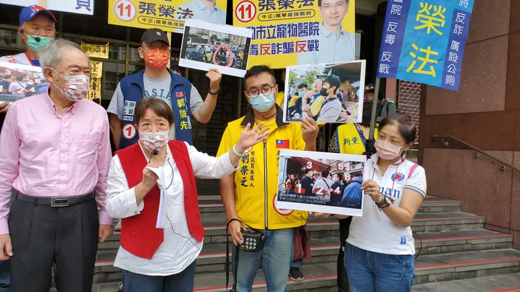 謝啟大指著張榮法被鎖喉的照片。呂志明攝