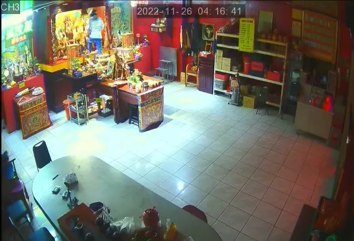 男子還爬上供桌，伸手直取金牌。民眾提供