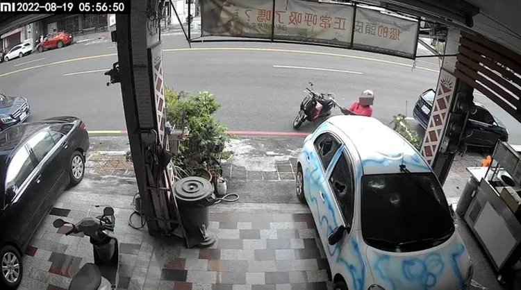 劉姓男子8月19日清晨，持棍棒砸毀美髮店老闆停在店門口的白色汽車。讀者提供