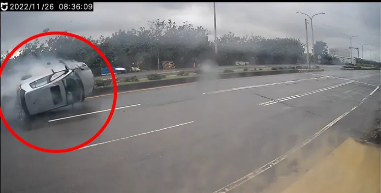 1輛銀色休旅車疑似飆速自撞分隔島當場翻車，全程被路旁的監視器拍下，驚險過程被分享在網路上。翻攝爆料公社