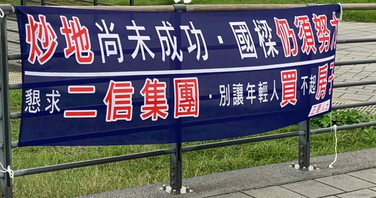 布條上寫下炒地尚未成功,國樑仍須努力,還署名正義人士。翻攝畫面