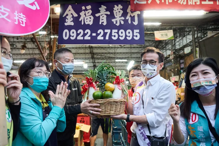 熱情的攤商送橘子祝福鄭運鵬大吉大利。鄭運鵬競辦提供