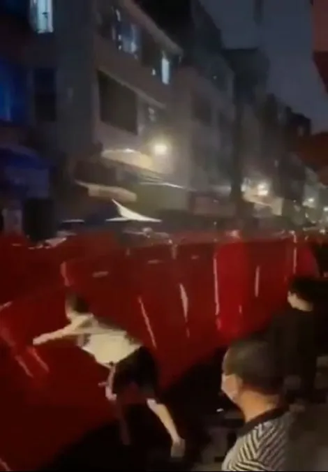 海珠區民眾14日衝到街上抗議封控措施，
怒氣沖沖推倒封控圍籬。翻攝微博@a2zumi