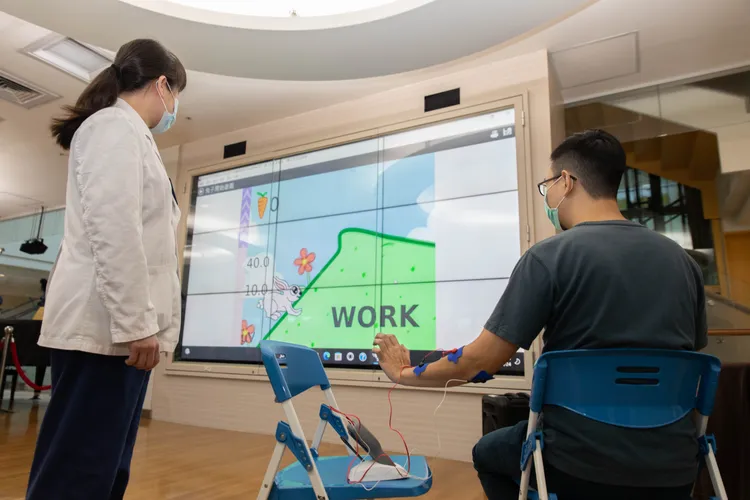 陽明交大醫院今年以「科技結合復健-生理回饋治療」參展，圖為現場示範體驗。院方提供