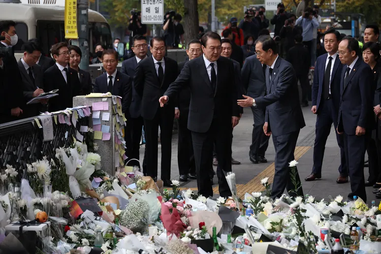 南韓總統尹錫悅（前排左）、國務總理韓悳洙（前排右）1日站在哀悼梨泰院踩踏事件死者的花海前面，神色凝重。路透社