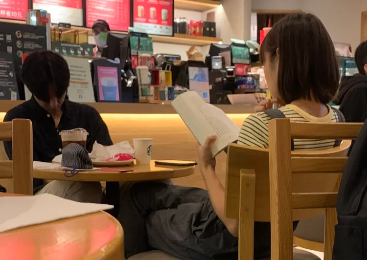 黃姵嘉（右）獨自看書，男友邱昊奇在旁度估。蔡依庭攝