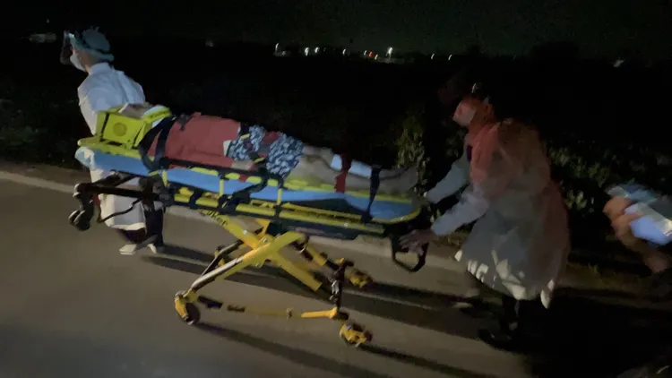 騎車雙載另一名男子準備送上救護車。侯昌騰攝