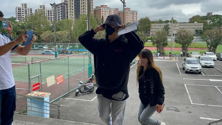 小孩頭戴漁夫帽，在親戚陪同抵達中和偵查隊。陸運陞攝