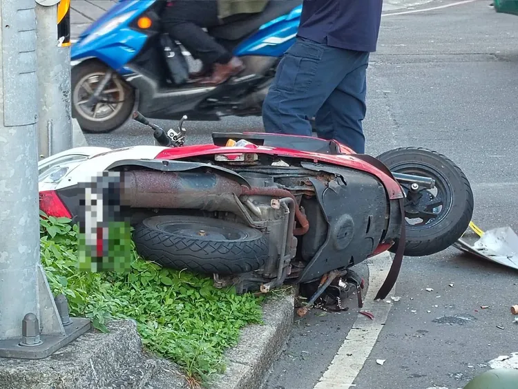 郭男騎乘的機車倒在中央分隔島。三重警分局提供