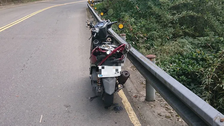 鄧男的機車自摔滑行，撞上護欄後停下。警方提供