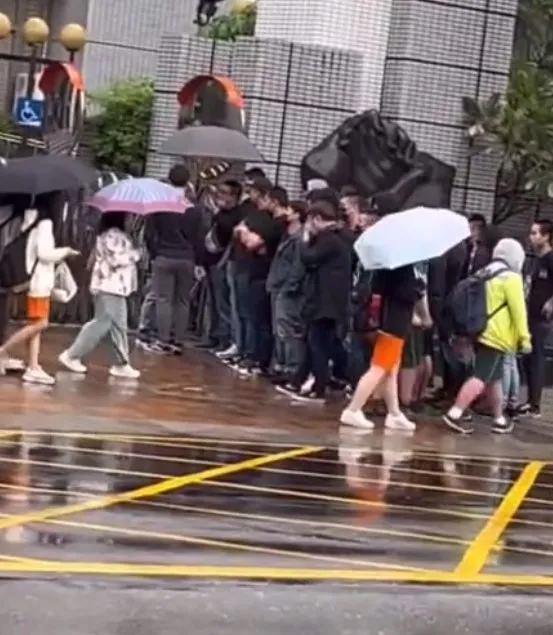 一排黑衣人站在校門外。記者爆料網