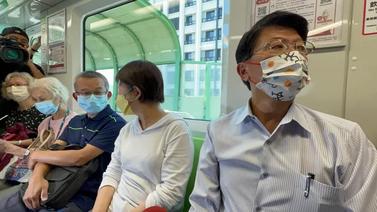 謝龍介在捷運上四處研究中捷車廂，盧秀燕跟旁邊乘客話家常。曾雪蒨攝
