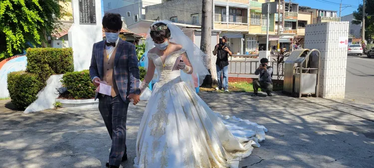 郎劉培誠與新娘侯思伊，今早穿西裝、婚紗走進投開票所投票。讀者提供