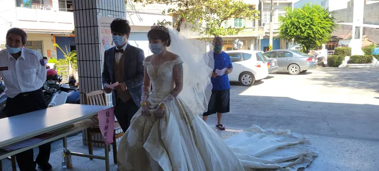 新郎劉培誠與新娘侯思伊今早穿西裝、婚紗，現身投票所投票。讀者提供