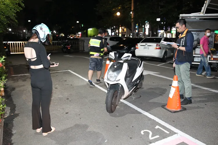 裸背美眉在場抄寫表格資料，等候車輛受檢。張喆喜攝