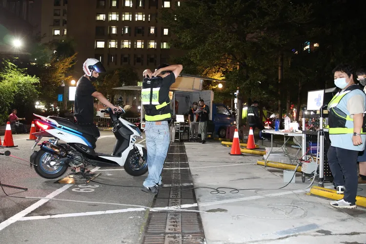 環保局檢測人員仔細檢查車籍、年份，再依照規定檢測機車噪音分貝值。張喆喜攝