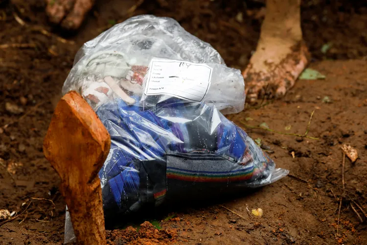 救難人員把一名死者的衣物裝入透明夾鏈袋。路透社