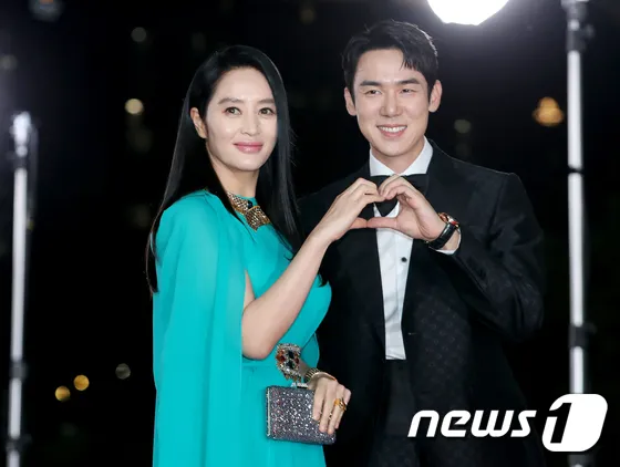 金惠秀（左）和柳演錫在紅毯上比愛心。翻攝ＮＥＷＳＮ