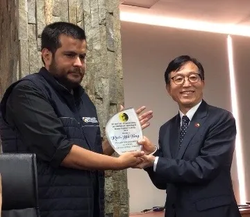 駐厄瓜多代表處代表莊輝恩代曾貴海領獎，左為詩歌節主席Augusto Rodríguez。外交部駐厄瓜多代表處提供