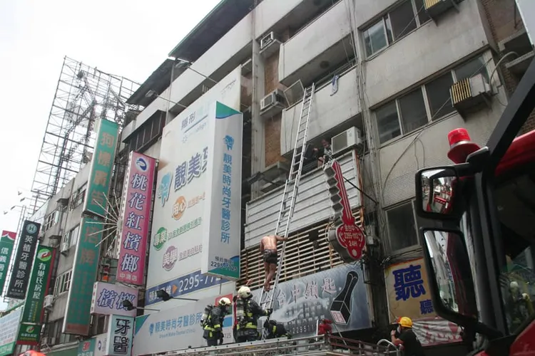 消防人員架梯救出在陽台揮手求救的受困民眾。翻攝臉書