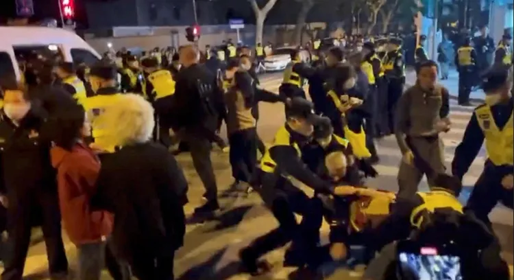 中國上海市27日深夜持續有民眾走上街頭參與「白紙革命」，警方在人群之中動手逮人。路透社