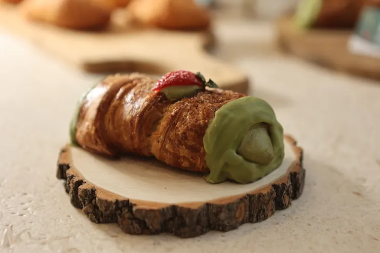 「聖誕綠可頌捲」在可頌外層淋上抹茶白巧克力醬，並點綴新鮮草莓營造聖誕經典紅綠配色。翁玉信攝