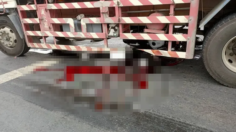 陳男撞機遭貨車輾壓車輪下，地面留有大片血跡。民眾提供