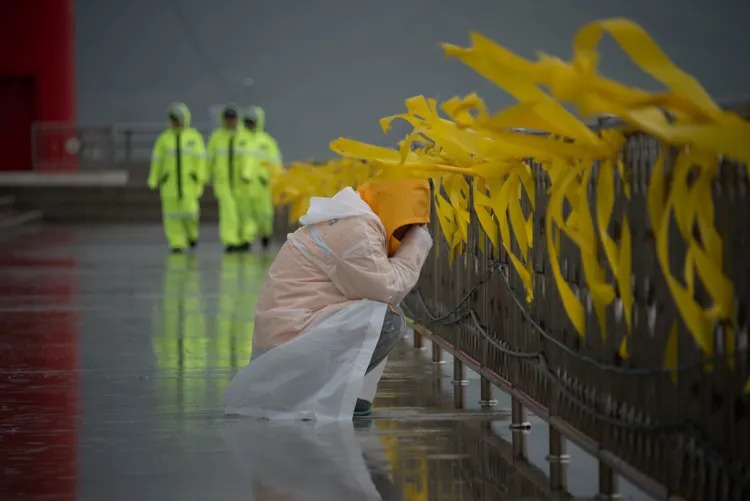 2014年世越號罹難者的家屬在岸邊掩面痛哭。法新社