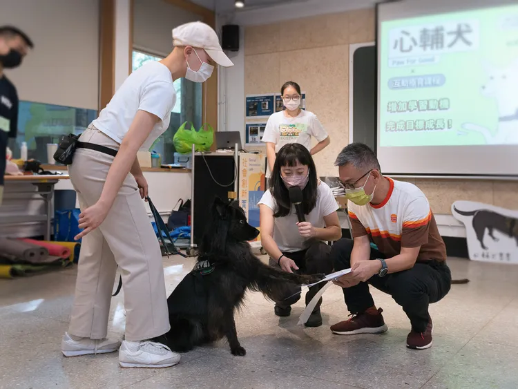 漢堡王執行長黃耀忠(右)、台灣心輔犬培育機構負責人陳奕君(左)正與「狗老師」建立信任關係。業者提供