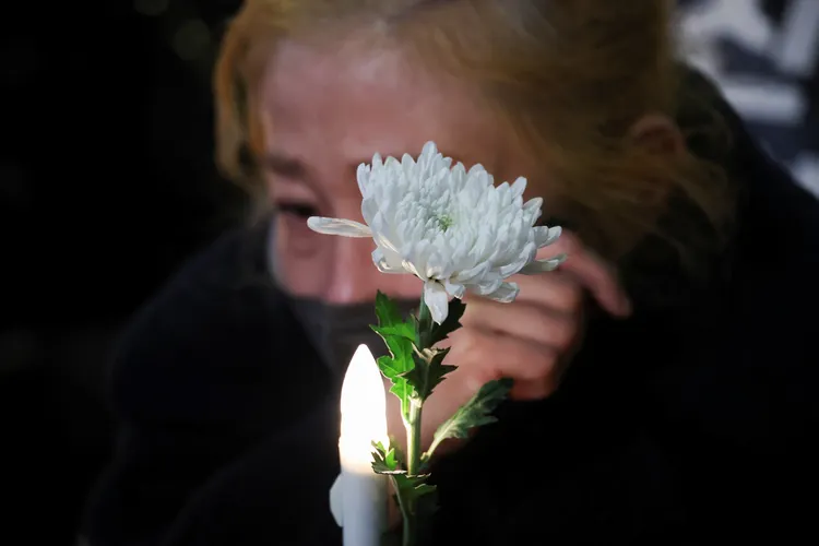 燭光悼念活動現場，民眾忍不住難過拭淚。路透社