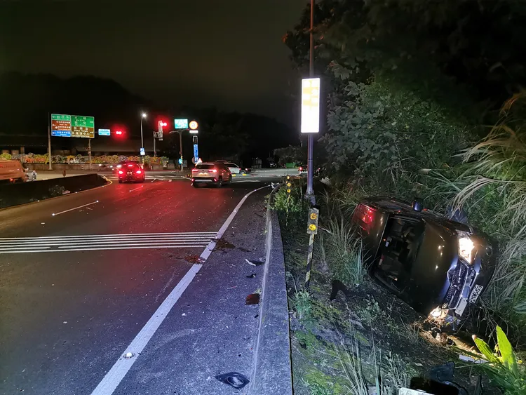 休旅車遭追撞翻落邊坡。陸運鋒攝