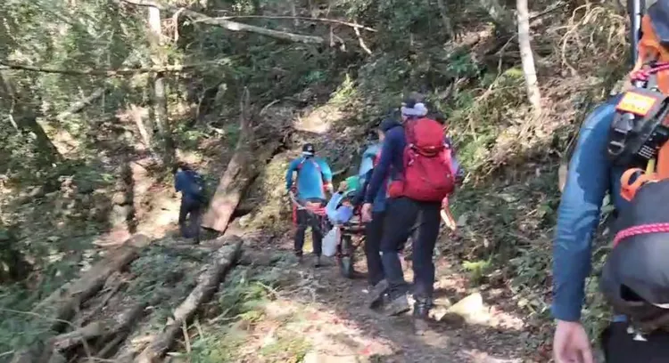 搜救人員與第二梯人員會合後，用獨輪車及體外自動按壓機搬運急救。民眾提供