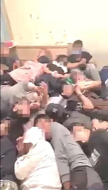 房內20多名男女，雙手遭綁、眼睛遭遮掩、嘴遭封閉，倒臥在房間地上。翻攝「爆料公社」