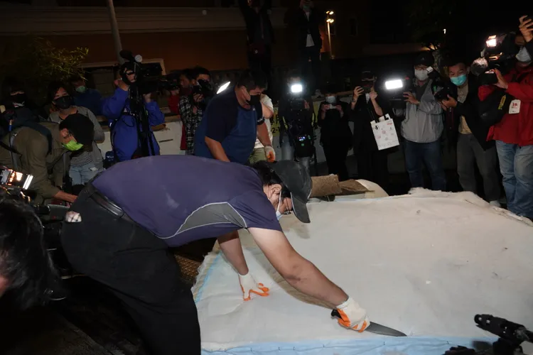 回收人員拿出刀子分解床墊。陳德興攝