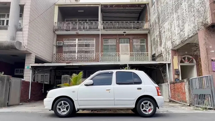 車主將白車臨停在自家與隔壁戶的圍牆前。王志弘攝