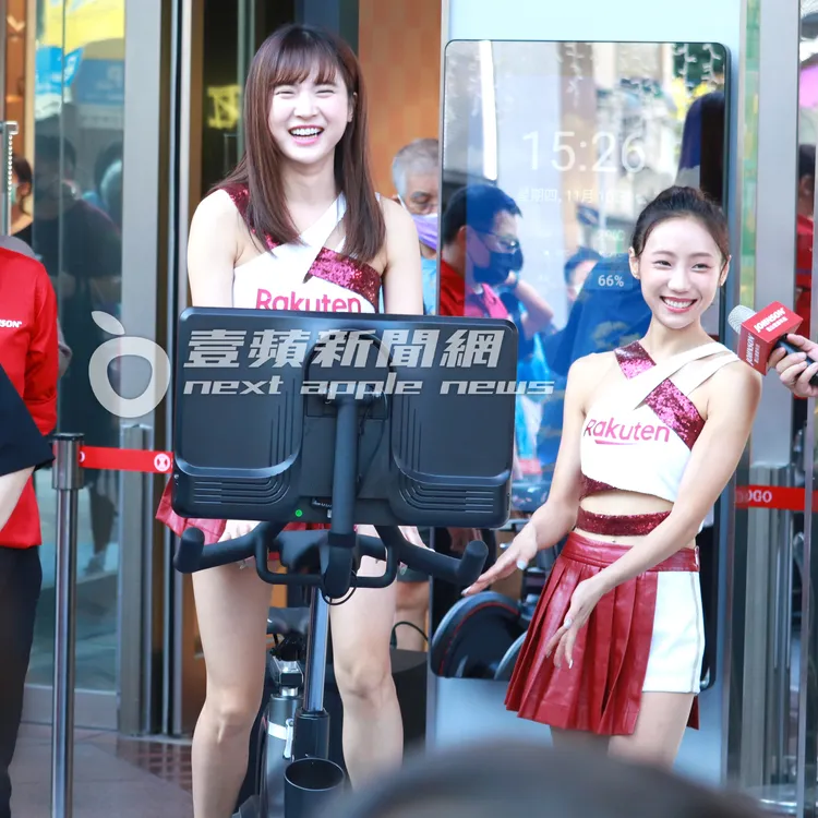 樂天桃猿啦啦隊「最正球經」孟潔（左），示範健身器材上上下下踩飛輪，和隊員卉妮笑開懷。特勤中心攝