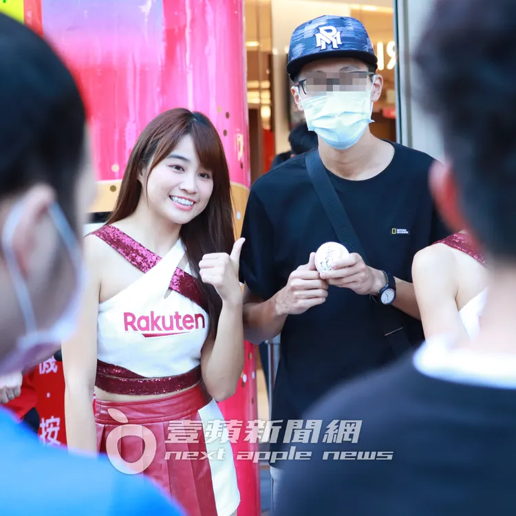 樂天桃猿啦啦隊人氣女神虎牙陳伊（左），在百貨周年慶活動中和男粉絲互動合照。特勤中心攝