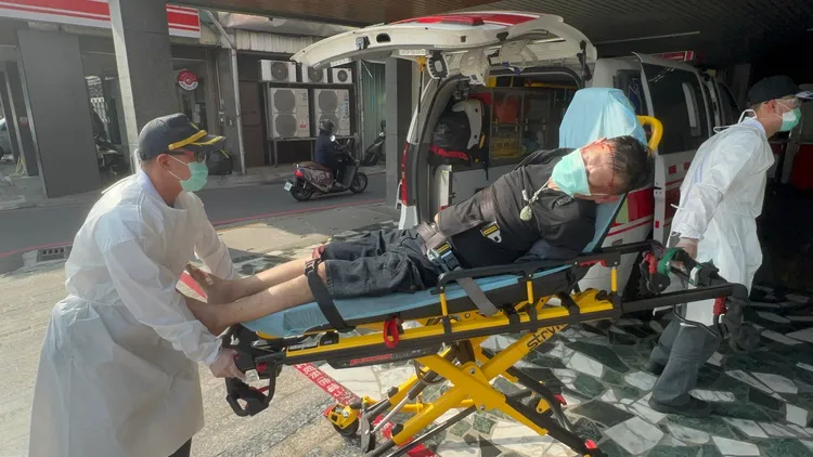 嫌犯陳姓男子遭碎裂的車窗玻璃割傷，被警方通知救護人員送醫包紮。侯昌騰攝