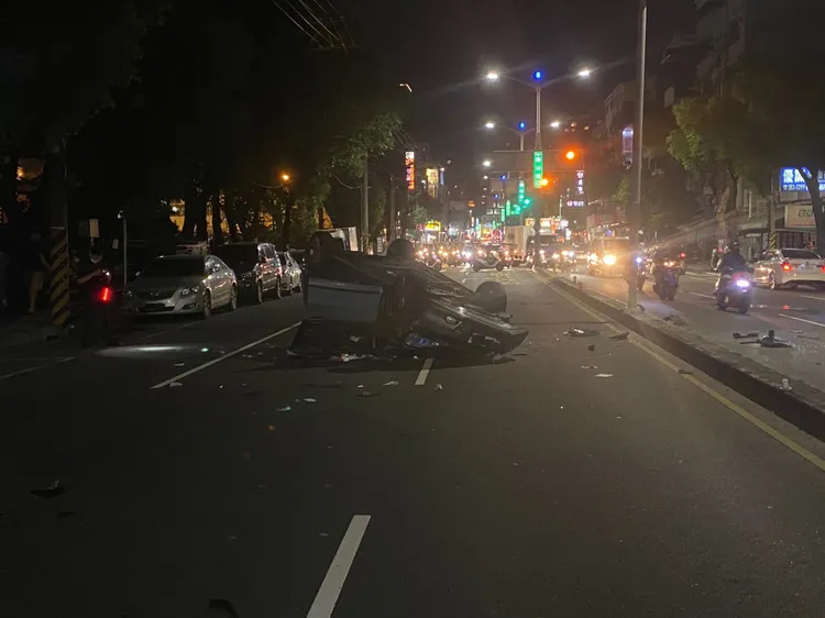 黑色汽車翻覆，車內駕駛與乘客已被救出。讀者提供